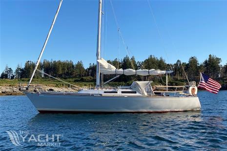 J Boats J/35 - 1984 J Boats J/35 sailboat on calm water with American flag.