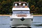 Prestige 550 - 2014 Prestige 550 yacht on calm water, front view with lush greenery background.