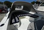 Eastern 248 Center Console - 2021 Eastern 248 Center Console boat with striped seating and canopy in a marina setting.