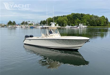 Pursuit C 280 Center Console - 2012 Pursuit C 280 Center Console boat on calm water near a marina.