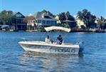 Robalo 1820 Center Console - 1994 Robalo 1820 Center Console boat on a calm lake near waterfront homes.