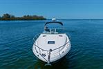 Sea Ray 320 Sundancer - 2006 Sea Ray 320 Sundancer boat on calm blue water, clear sky background.