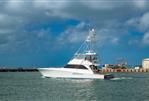 Viking Sportfish - 2006 Viking Sportfish yacht cruising near a dock under cloudy skies.