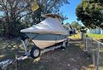 Scout 215 XSF - 2018 Scout 215 XSF boat on trailer, covered, parked in a grassy yard.