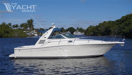 Sea Ray 340 Amberjack - 2002 Sea Ray 340 Amberjack boat on a calm river with lush greenery.