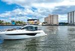 Galeon 47 Sky - 2022 Galeon 47 Sky yacht cruising near city waterfront under cloudy sky.