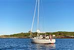 J Boats J/35 - 1984 J Boats J/35 sailboat anchored in calm waters under clear blue sky.