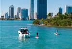 Jeanneau NC 895 S2 - 2025 Jeanneau NC 895 S2 boat on turquoise water near city skyline.