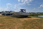 Chaparral 264 Sunesta - 2012 Chaparral 264 Sunesta boat on trailer, parked on grassy field under blue sky.