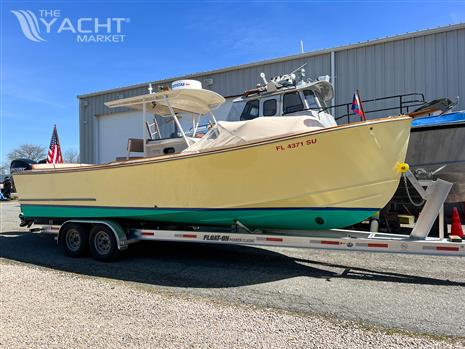 Padebco V27 Center Console - 2003 Padebco V27 Center Console boat on trailer, parked outside a warehouse.