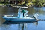 Shallow Sport 24 Mod V - 2021 Shallow Sport 24 Mod V boat on calm water near a wooded shoreline.