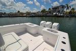 SeaHunter 33 - 2018 SeaHunter 33 boat with triple Mercury engines docked by waterfront homes.