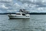 Carver 4207 - 1987 Carver 4207 yacht on a calm lake under cloudy skies.