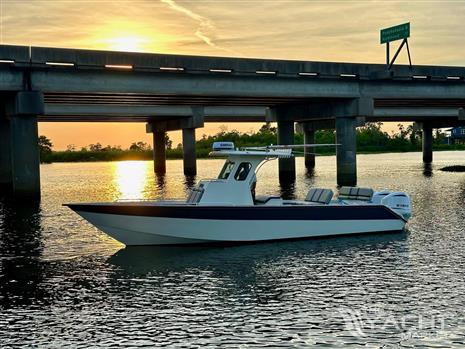 Custom Leblanc CC - Custom 2003 Leblanc CC boat on water at sunset near bridge.