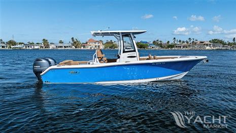 Sea Hunt 265 ultra - 2022 Sea Hunt Ultra 265 SE boat on calm water, blue hull, clear sky background.