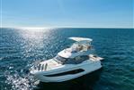 Prestige 420 - Luxury 2020 Prestige 420 yacht cruising on open sea under clear blue sky.