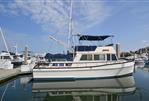 Grand Banks 42 Classic - 1985 Grand Banks 42 Classic yacht docked at marina under blue sky.