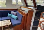 Monk 38 - 1978 Monk 38 boat interior with blue seating, wooden accents, and nautical decor.