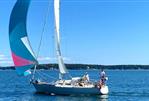 J Boats J/35 - 1984 J Boats J/35 sailing on a clear blue sea with colorful spinnaker.