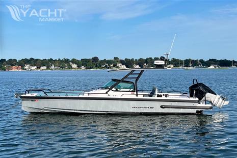 Axopar 28 T-Top - 2023 Axopar 28 T-Top boat on calm water with scenic shoreline background.