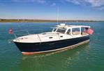 MJM 36z Downeast - 2015 MJM 36z Downeast boat on calm water, featuring flags and sleek design.