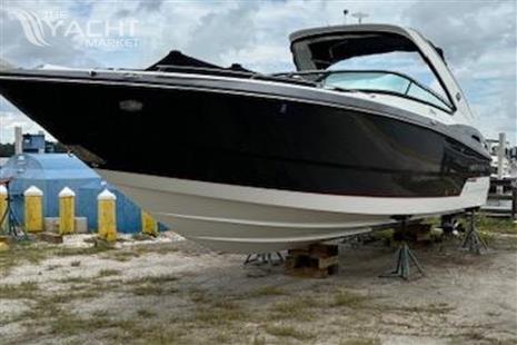 Monterey 328SS - 2015 Monterey 328SS boat on stands, black and white hull, outdoor setting.