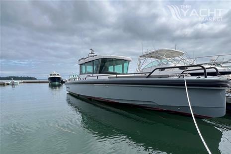 Axopar 28 CABIN - 2019 Axopar 28 CABIN boat docked on calm water under cloudy sky.