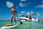 Jeanneau Leader 12.5 - Man paddleboarding near 2024 Jeanneau Leader 12.5 boat with people enjoying the water.