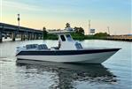 Custom Leblanc CC - Custom 2003 Leblanc CC boat on calm water near a bridge at sunset.