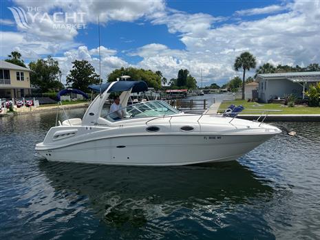 Sea Ray 260 Sundancer - 2005 Sea Ray 260 Sundancer boat cruising on a sunny day in a residential canal.