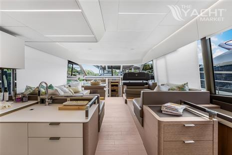 Prestige 590 flybridge - Luxurious interior of 2024 Prestige 590 flybridge yacht with modern kitchen and seating area.