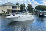 Sea Ray 260 Sundancer - 2005 Sea Ray 260 Sundancer boat on a calm lake near a house.