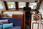 Monk 38 - 1978 Monk 38 boat interior with wooden helm, blue seating, and nautical decor.