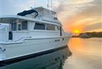 Hatteras 62 Cockpit Motor Yatch - 1990 Hatteras 62 Cockpit Motor Yacht at sunset on calm water.