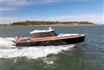 Boston Boatworks Daychaser 48 - 2024 Boston Boatworks Daychaser 48 cruising on open water, American flag waving.