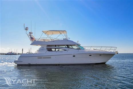 Jeanneau Prestige 46 - 2006 Jeanneau Prestige 46 yacht cruising on calm waters under clear blue sky.