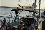 Pearson 35 - 1971 Pearson 35 sailboat docked at sunset, featuring American flag and green canopy.