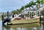 Padebco V27 Center Console - 2003 Padebco V27 Center Console boat docked near palm trees and waterfront homes.