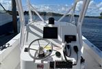 Vanquish Bristol Harbor 23 - 2020 Vanquish Bristol Harbor 23 boat dashboard with steering wheel and controls, docked by the water.