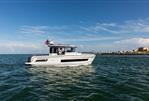 Jeanneau NC Sport 895 - 2024 Jeanneau NC Sport 895 boat cruising on open water under a clear blue sky.