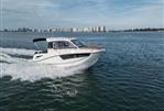 Bayliner T25 EXPLORER - 2024 Bayliner T25 EXPLORER cruising on open water with city skyline in background.