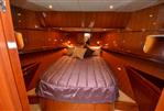 Hampton 580 Pilot House - Luxurious bedroom in a 2009 Hampton 580 Pilot House yacht with wood paneling.