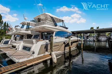 Prestige 520 - 2024 Prestige 520 yacht docked at marina under clear blue sky.