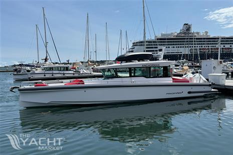 Axopar 37 Cross Cabin - 2021 Axopar 37 Cross Cabin boat docked in marina, clear sky, cruise ship in background.