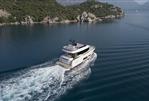 Sirena 48 - Sirena 48 yacht cruising in serene waters, surrounded by lush green hills, 2025 model.