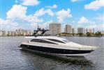 Amer 94 - Luxurious 2017 Amer 94 yacht cruising near city skyline under blue sky.