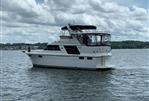 Carver 4207 - 1987 Carver 4207 yacht cruising on a lake under cloudy skies.