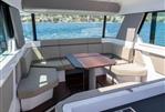 Axopar 45 - 2024 Axopar 45 interior with panoramic windows and modern seating.