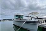 Axopar 28 CABIN - 2019 Axopar 28 CABIN boat docked in a marina under cloudy skies.