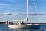 J Boats J/35 - 1984 J Boats J/35 sailboat on calm water with American flag.